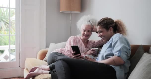 Une femme adulte regarde un téléphone intelligent avec sa fille — Video