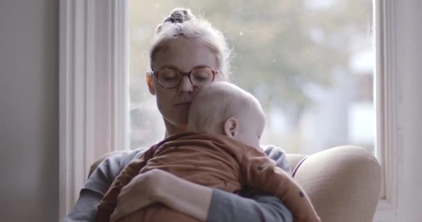 Egyedülálló anya vigasztaló bébiszitter ül széken a nappaliban — Stock videók