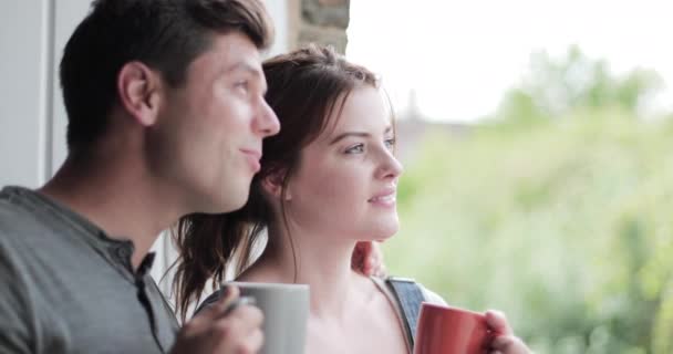 Jeune couple d'adultes regardant par la fenêtre dans une nouvelle maison — Video