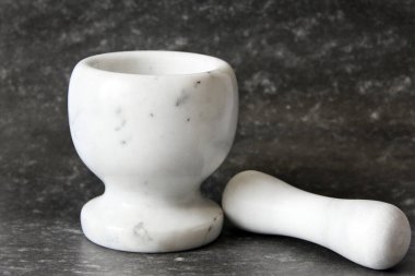 Stupa - ezmek ve öğütmek için bir araç. Siyah arka planda beyaz tabaklar