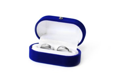 Beyaz arka planda tabutta altın yüzükler. Beyaz altın