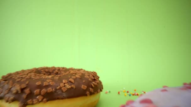 老瓦24毫米探头镜头通过美丽的彩色甜甜圈 好吃的甜甜圈关门了 甜甜的甜点撒播 绿色背景 在甜甜圈里面4K — 图库视频影像
