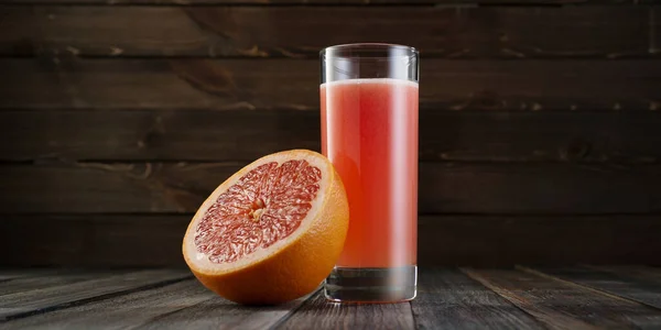 Taze sıkılmış greyfurt suyu ahşap zemin üzerinde yüksek bir bardakta. Plastik sahne, taze meyve suyu.