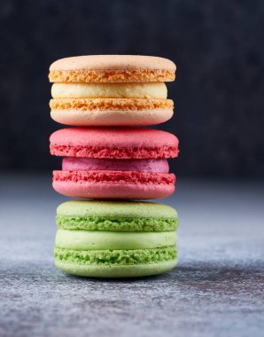 Masada üç renkli badem kurabiyesi yığını var. Mükemmel şekilli badem kurabiyeleri, tatlı tatlı  