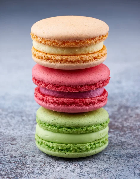 Masada üç renkli badem kurabiyesi yığını var. Mükemmel şekilli badem kurabiyeleri, tatlı tatlı