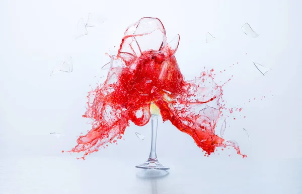 Kırmızı ve beyaz şarap kadehleri çarpışıyor ve beyaz arka planda eziliyor. Sıçramalar. Kırık cam. Sıvıların yüksek hız fotoğrafçılığı