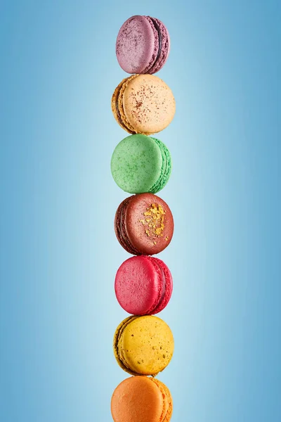 Açık mavi arkaplanda renkli badem kurabiyeleri 