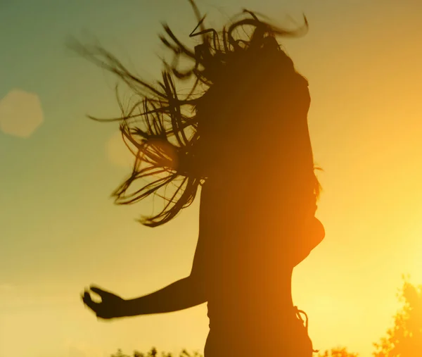 female silhouette with an emotional splash. musician or actor in courage against the backdrop of a beautiful sunset