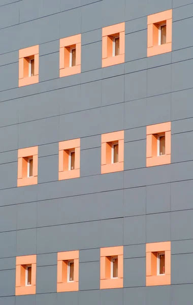 small pink square windows in the wall of a building of modern architecture