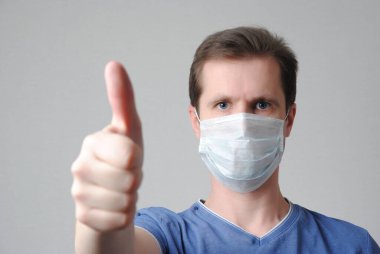 Tıbbi maskeli adam baş parmağını kaldırdı.
