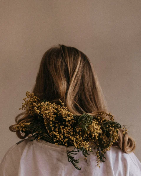 Sarışın Bir Kız Arkası Dönük Duruyor Sarı Bir Mimoza Dalı — Stok fotoğraf