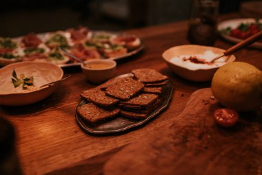 Ahşap masada servis için aperatifler ve kesim tahtası var..