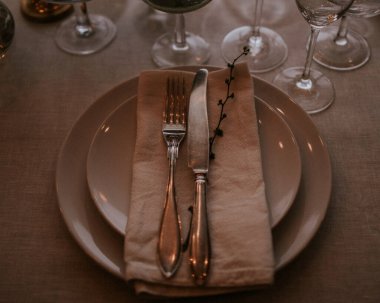 Çatal ve bıçak bir tabakta keten peçeteyle..