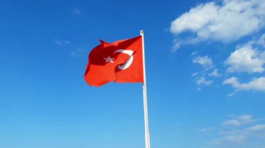 Mavi gökyüzünde yaz güneşli günde çırpınan Türkiye'nin bayrak. Video.