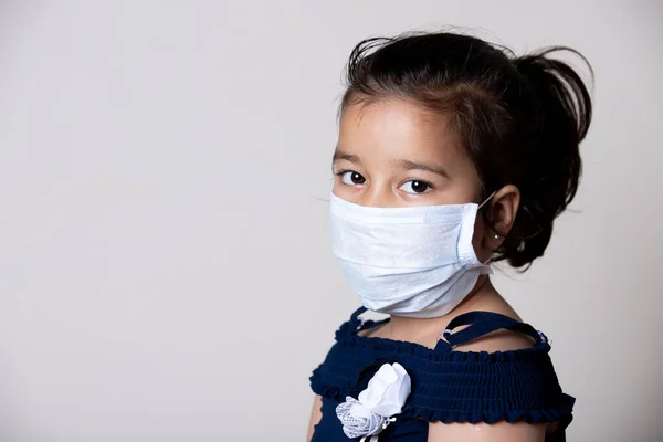 Indian Girl Child Face Covered with Mask at home to prevent from the Spread of Corona virus Infection.