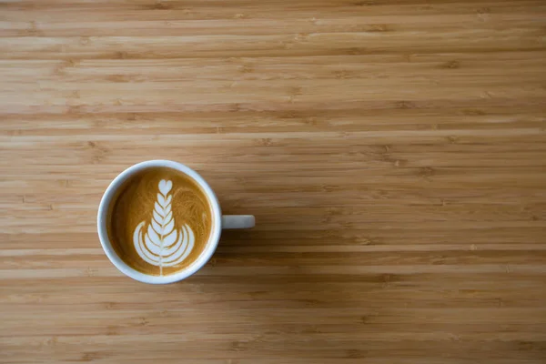 Горячий кофе латте на деревянном столе — стоковое фото