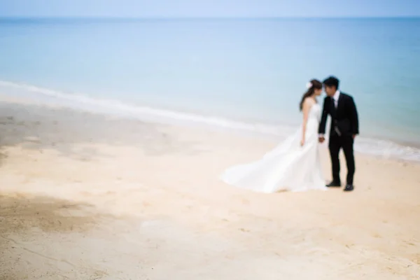 Fuera de foco de novia y novio en la playa tropical — Foto de Stock