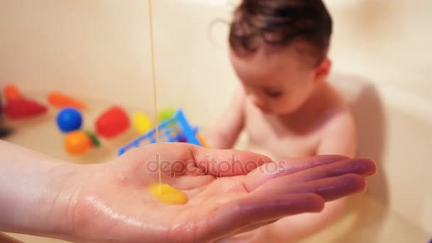 Baby wassen in het bad. Gebruik zeep, shampoo voor kinderen. — Stockvideo