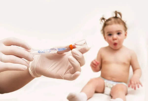 Врач держит шприц для вакцинации ребенка инъекцией — стоковое фото