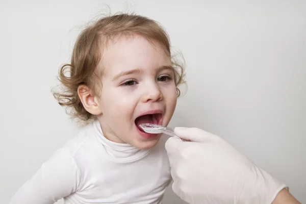 Petite fille prenant des médicaments avec cuillère — Photo