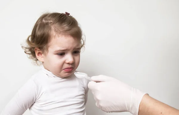 Menina bebê tomando remédio com colher — Fotografia de Stock