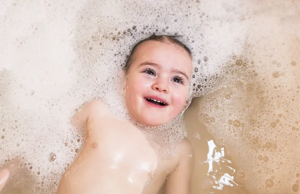 Happy baby girl tvářička plavání v koupelně a úsměv — Stock fotografie