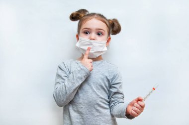 Tek kullanımlık maskeli küçük kız parmağını kaldırdı. Coronavirus salgını koruması
