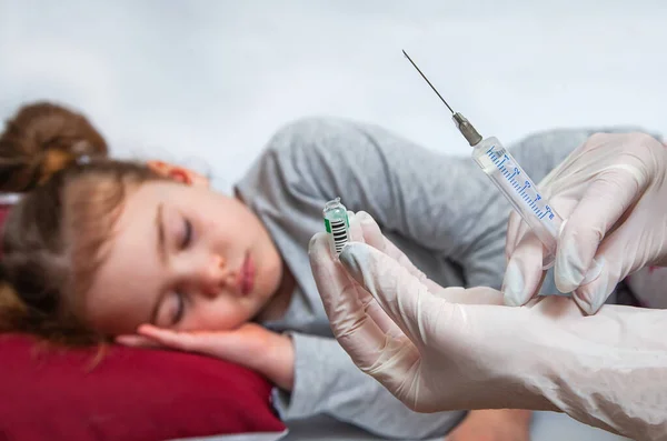A enfermeira tem uma seringa para injectáveis para a menina. Um médico com luvas médicas prepara uma seringa . — Fotografia de Stock