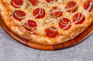 Gri arka planda pepperoni pizza.