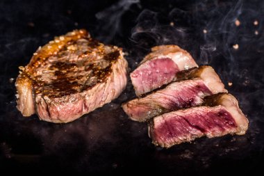 Tipik Brezilya bifteği, ızgara Picanha bifteği ve sıcak demir tabakta çıkan dumanlı biftek..