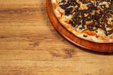 Ahşap arka planda Shitake mantarlı pizza. en üstteki görünüm.