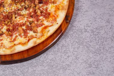 Pastırmalı lezzetli pizza ve gri arka planda kızarmış sarımsak..