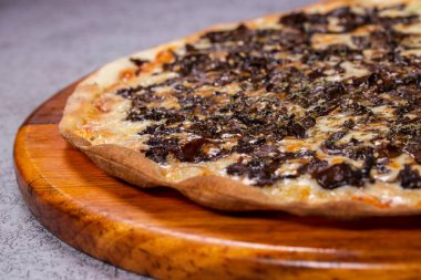 Gri arka planda Shitake mantarlı pizza.