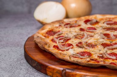 Gri arka planda pepperoni pizza.