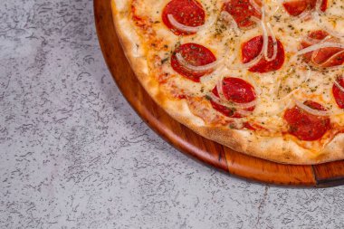 Gri arka planda pepperoni pizza.