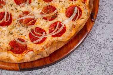 Gri arka planda pepperoni pizza.