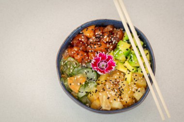 Hawaii somonu, deniz yosunu, çiğ somon, avokado, ananas, salatalık ve susam tohumu. Yukarıdan görüntüle.