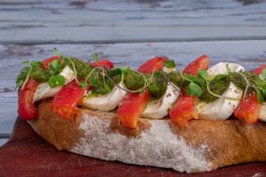 Buffalo mozzarella bruschetta ile domates ve soslu rustik arka plan.