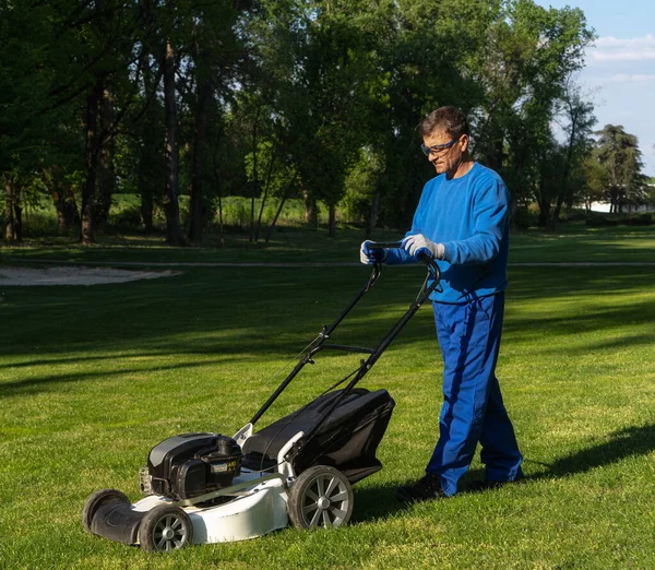 A man mows the lawn, the worker mows a lawn image,maintenance of greenery