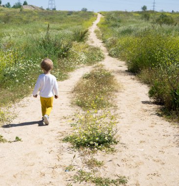 Özgürce papatya tarlasında koşan çocuk.