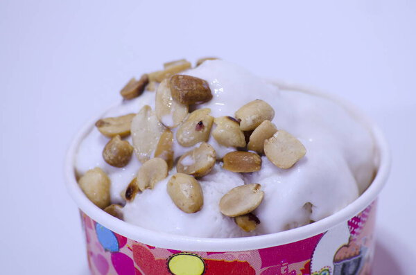 Coconut milk ice cream topped with peanuts in a fancy cup.