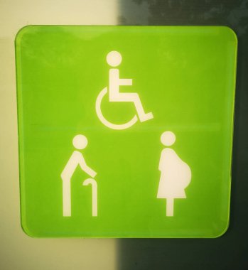 Özürlü insanlar, yaşlı, hamile kadınlar için yeşil arka planda beyaz