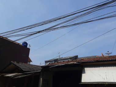 Jakarta 'da bir evin çatısında elektrik kabloları var. düzgün düzenlenmemiş ev kabloları.