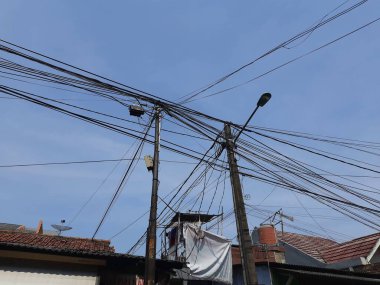 Jakarta 'da bir evin çatısında elektrik kabloları var. düzgün düzenlenmemiş ev kabloları.