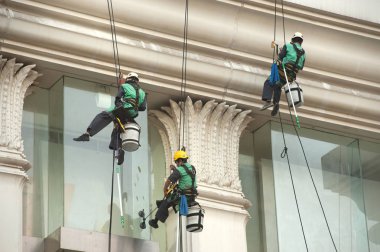Yüksek bir binanın üzerinden cam temizleyici abseiling. 