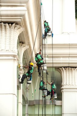 Yüksek bir binanın üzerinden cam temizleyici abseiling. 