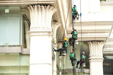 Yüksek bir binanın üzerinden cam temizleyici abseiling. 