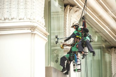 Yüksek bir binanın üzerinden cam temizleyici abseiling. 