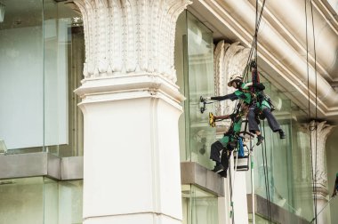 Yüksek bir binanın üzerinden cam temizleyici abseiling. 