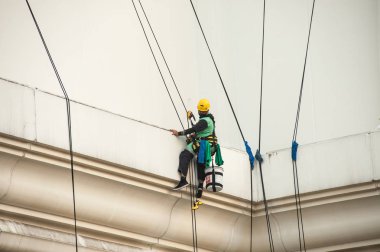 Yüksek bir binanın üzerinden cam temizleyici abseiling. 